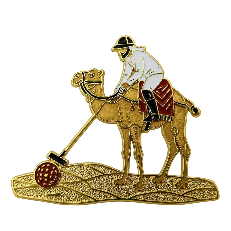 Camel polo player gold enamel pin on a textured sand base