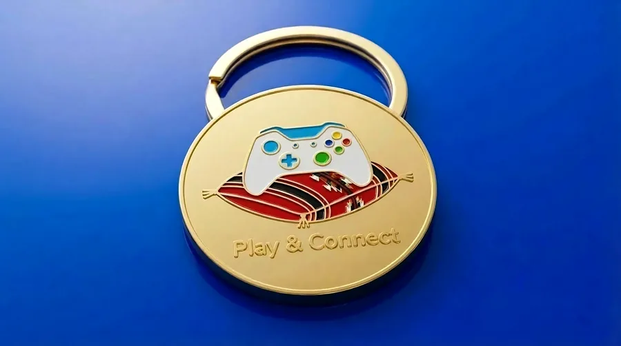 Play and Connect enamel keychain with a game controller on a Sadu-pattern cushion